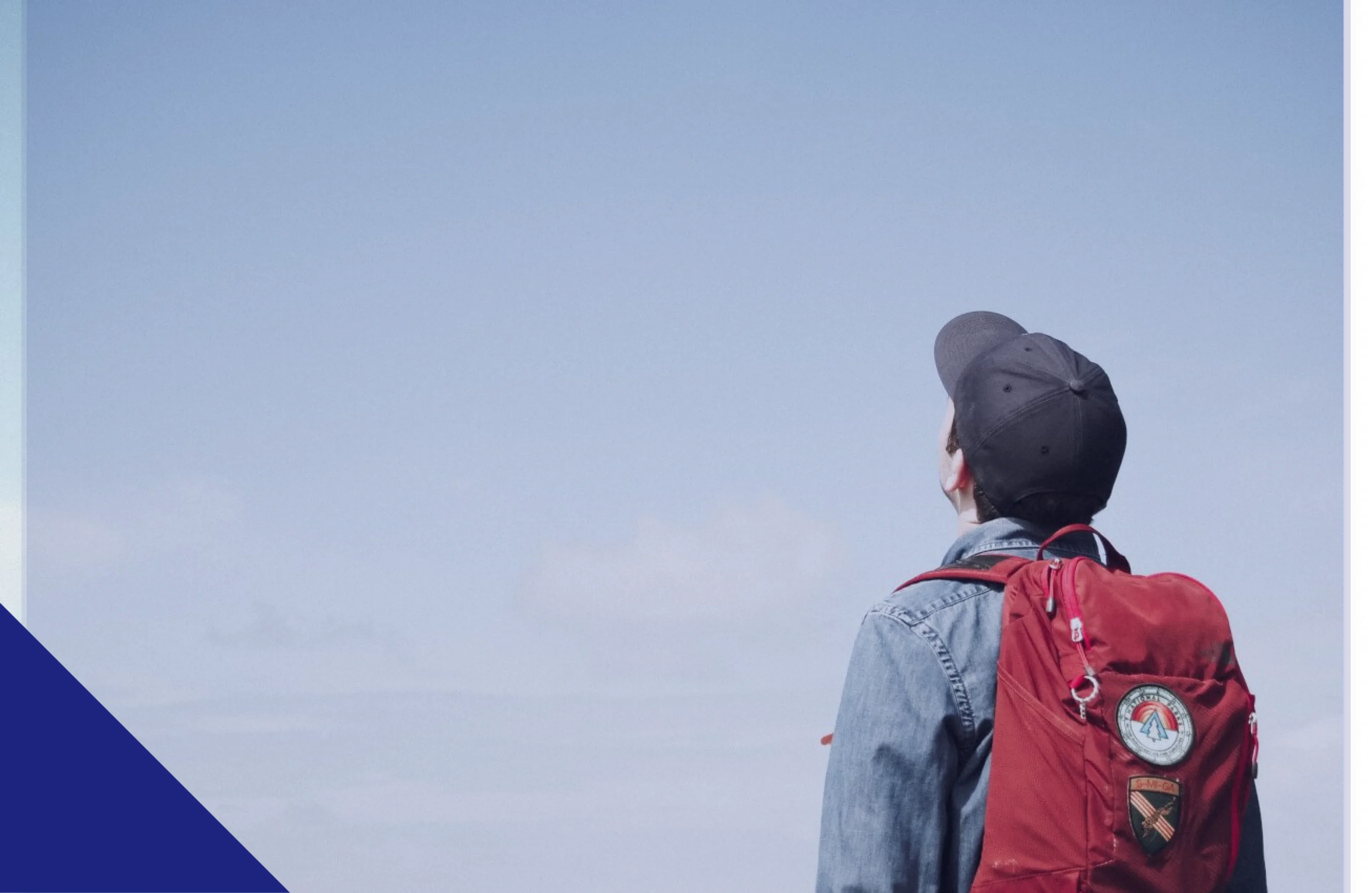 boy-with-hat-and-red-bag-looking-up-1 1